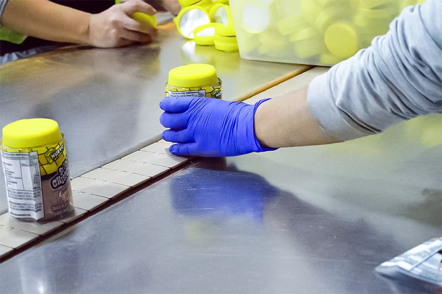 Personal de producción cumpliendo protocolos de higiene y Buenas Prácticas de Manufactura en planta alimenticia